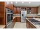Gourmet kitchen boasts stainless steel appliances, granite countertops, and custom cabinetry at 19616 E Pinewood Dr, Aurora, CO 80016