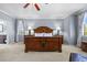 Spacious main bedroom featuring a decorative wood bed frame, soft carpet, and ensuite bathroom access at 19616 E Pinewood Dr, Aurora, CO 80016
