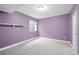 This bedroom offers neutral carpet, a window, and lavender colored walls at 222 S Olive St, Denver, CO 80230