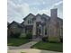 Charming two-story home features a brick chimney, manicured lawn, and inviting front entrance at 222 S Olive St, Denver, CO 80230
