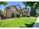 Charming two-story brick home with a manicured lawn and mature trees at 222 S Olive St, Denver, CO 80230