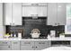 Stylish kitchen featuring gray cabinets, black backsplash, and modern appliances at 222 S Olive St, Denver, CO 80230