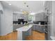 Modern gray kitchen featuring stainless appliances, a white island, and unique pendant lighting at 222 S Olive St, Denver, CO 80230