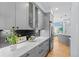 Kitchen showcases gray cabinets, quartz counters, black backsplash, stainless appliances, and hardwood floors at 222 S Olive St, Denver, CO 80230