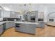 Modern kitchen features gray cabinets, hardwood floors, stainless appliances, and a large island at 222 S Olive St, Denver, CO 80230