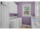 Functional laundry room offers white cabinets, updated appliances, and a window at 222 S Olive St, Denver, CO 80230