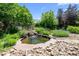 Picturesque backyard pond with cascading waterfall surrounded by lush greenery and stone accents at 222 S Olive St, Denver, CO 80230
