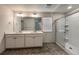 Bright bathroom with a double sink vanity and a glass-enclosed shower with a window at 2325 Mountain Sky Dr, Fort Lupton, CO 80621