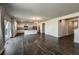 Spacious living room with wood floors leading to the modern kitchen with island, ideal for gathering and entertaining at 2325 Mountain Sky Dr, Fort Lupton, CO 80621