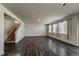 Spacious living room featuring hardwood floors, large windows, and a staircase at 2325 Mountain Sky Dr, Fort Lupton, CO 80621