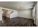 Neutral living space with wood floors and access to the staircase and entryway at 2325 Mountain Sky Dr, Fort Lupton, CO 80621