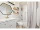 A charming bathroom with a framed mirror, wood shelves, and a shower-bathtub combination at 16397 E Wyoming Dr, Aurora, CO 80017