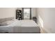 A serene bedroom with a soft bed, chair, and a bookshelf, bathed in gentle sunlight at 16397 E Wyoming Dr, Aurora, CO 80017