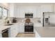 Modern kitchen boasting stainless appliances, sleek white cabinets, and light wood floor at 16397 E Wyoming Dr, Aurora, CO 80017