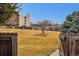 Large grassy backyard offering lots of room for outdoor activities, framed by mature trees and a blue sky at 7250 Eastmoor Dr # 119, Denver, CO 80237