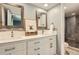 Modern bathroom featuring double sinks, white cabinetry, updated mirrors, and a glass enclosed shower at 7250 Eastmoor Dr # 119, Denver, CO 80237