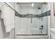 Bright bathroom featuring a shower over tub with white tile walls and a decorative blue accent at 7250 Eastmoor Dr # 119, Denver, CO 80237