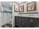 Bathroom featuring dual marble sinks, dark cabinets, and glass-enclosed tiled shower at 7250 Eastmoor Dr # 119, Denver, CO 80237