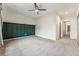 Bedroom with neutral carpet, ceiling fan, and dark green accent wall at 7250 Eastmoor Dr # 119, Denver, CO 80237