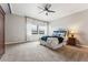 Spacious carpeted bedroom with windows offering natural light and a ceiling fan at 7250 Eastmoor Dr # 119, Denver, CO 80237