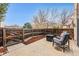 Cozy patio with wooden fence, fire pit, and outdoor seating, ideal for relaxing and entertaining at 7250 Eastmoor Dr # 119, Denver, CO 80237