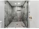 A modern shower with gray tiling, a glass door, and a rainfall shower head at 7250 Eastmoor Dr # 119, Denver, CO 80237