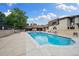 Community swimming pool with lounge chairs, sun umbrellas, and a nearby building at 7250 Eastmoor Dr # 119, Denver, CO 80237