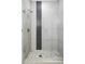 Contemporary shower with pebble floor, black tiled accent stripe, and glass door at 3635 Osage St, Denver, CO 80211