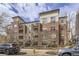 Attractive brick apartment building with balconies, surrounded by blossoming trees and nearby parking at 1623 Saint Paul St # 306, Denver, CO 80206