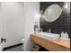 Stylish powder room with a floating wood vanity, modern fixtures, and a black-tiled accent wall provides a sophisticated touch at 3256 S Corona, Englewood, CO 80113