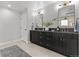 A contemporary bathroom featuring double vanity with black cabinets, gold hardware and a neutral tile floor at 3256 S Corona, Englewood, CO 80113