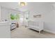 The Bedroom features a white crib, glider, and natural light, perfect for a calm and serene environment at 3256 S Corona, Englewood, CO 80113