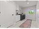 Well-organized laundry room featuring modern washer and dryer, ample cabinet space, and stylish tile flooring at 3256 S Corona, Englewood, CO 80113