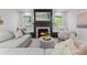Cozy living room features a fireplace, plush seating, and natural light from two windows with built-in benches at 3256 S Corona, Englewood, CO 80113