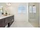 Modern bathroom with double vanity, granite countertop, and walk-in shower at 13960 Box Turtle Loop, Parker, CO 80134