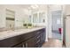 Bathroom featuring double vanity with marble countertops, mirrors, and a view of the adjacent room at 13960 Box Turtle Loop, Parker, CO 80134