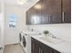 Bright laundry room features a modern washer and dryer, sink and dark cabinets for ample storage at 13960 Box Turtle Loop, Parker, CO 80134