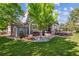 Expansive backyard featuring a hot tub, covered patio with outdoor seating, and lush green lawn for relaxation at 10660 Weathersfield Ct, Highlands Ranch, CO 80129