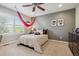 A cozy bedroom with a unique hammock chair feature, ceiling fan and large sunny windows at 10660 Weathersfield Ct, Highlands Ranch, CO 80129