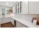 Well-appointed butler's pantry with white cabinets, counter space, and a beverage refrigerator at 10660 Weathersfield Ct, Highlands Ranch, CO 80129