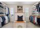 Walk-in closet with custom shelving and a built-in bench between two bright windows at 10660 Weathersfield Ct, Highlands Ranch, CO 80129