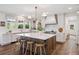 Bright kitchen features a large island with bar seating, white cabinets, and stainless steel appliances at 10660 Weathersfield Ct, Highlands Ranch, CO 80129