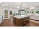 Bright kitchen with a large center island, stainless steel appliances and adjacent living and dining spaces at 10660 Weathersfield Ct, Highlands Ranch, CO 80129