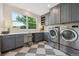 Well-organized laundry room featuring built-in storage, a utility sink, and a large window offering ample natural light at 10660 Weathersfield Ct, Highlands Ranch, CO 80129
