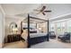 Spacious main bedroom with a four poster bed, ceiling fan and large windows for natural light at 10660 Weathersfield Ct, Highlands Ranch, CO 80129