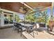 Outdoor covered patio complete with ceiling fan, full dining set, outdoor living room and convenient built-in grill area at 10660 Weathersfield Ct, Highlands Ranch, CO 80129