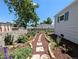 Landscaped backyard with beautiful flower garden, stone walkway and tall shade tree at 2032 Tulane St, Denver, CO 80260