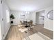 Cozy dining room featuring a modern chandelier and wood-look flooring adjacent to kitchen at 2032 Tulane St, Denver, CO 80260