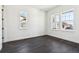 Neutral bedroom with two large windows and dark hardwood flooring at 3884 Freestone Pt, Castle Rock, CO 80108
