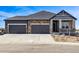 Beautiful two-story home with stone accents, a three car garage, and manicured landscaping at 3884 Freestone Pt, Castle Rock, CO 80108